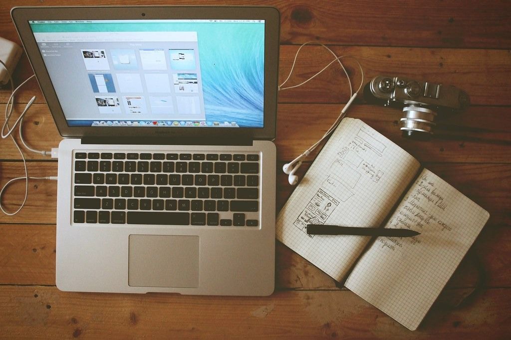 Laptop and notebook on a wooden desk